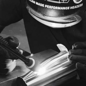 Man creating custom headers for a performance shop using GP Header's expertise.